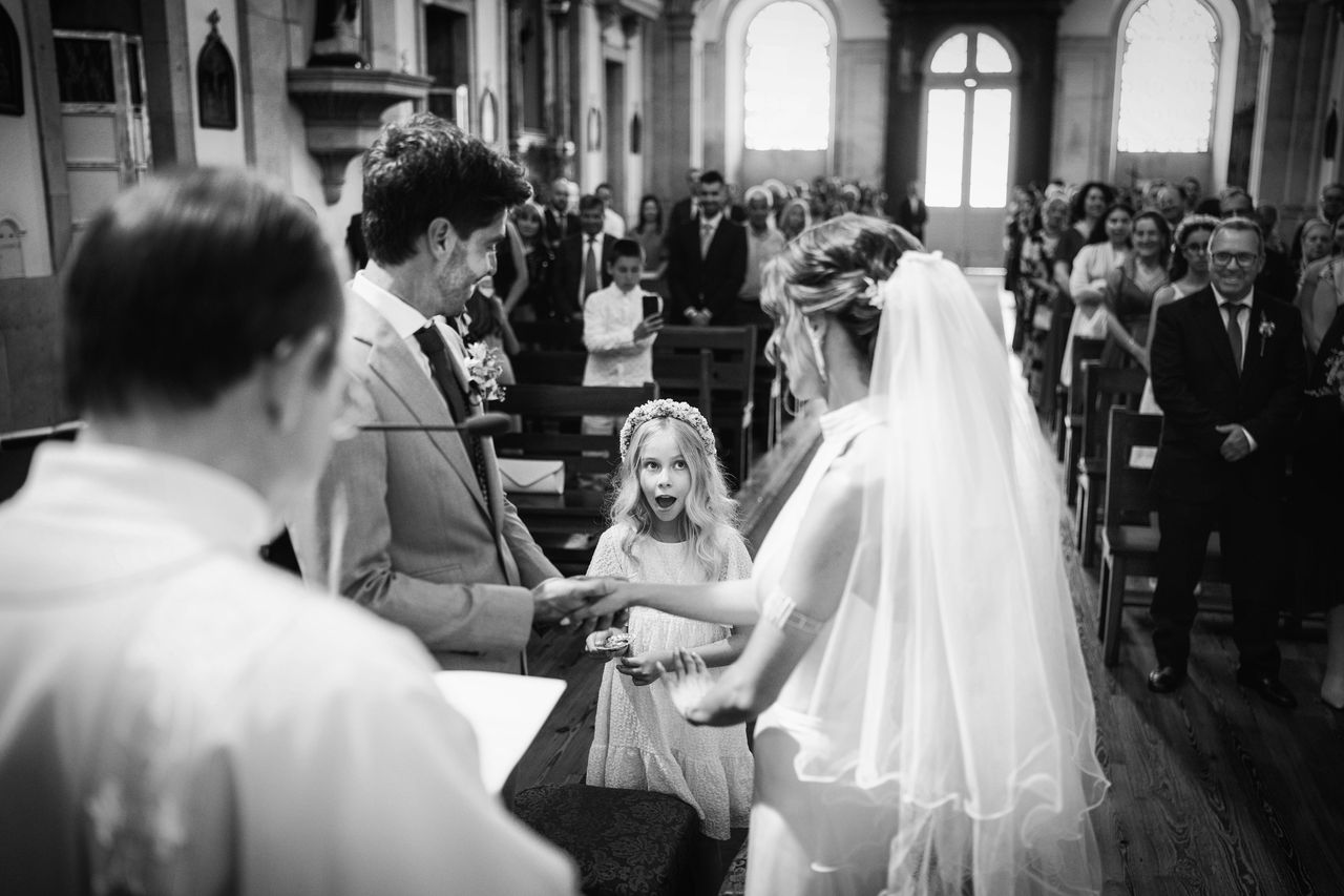 Intercambio de anillos en iglesia durante ceremonia de casamiento, fotografía en blanco y negro con momento espontáneo